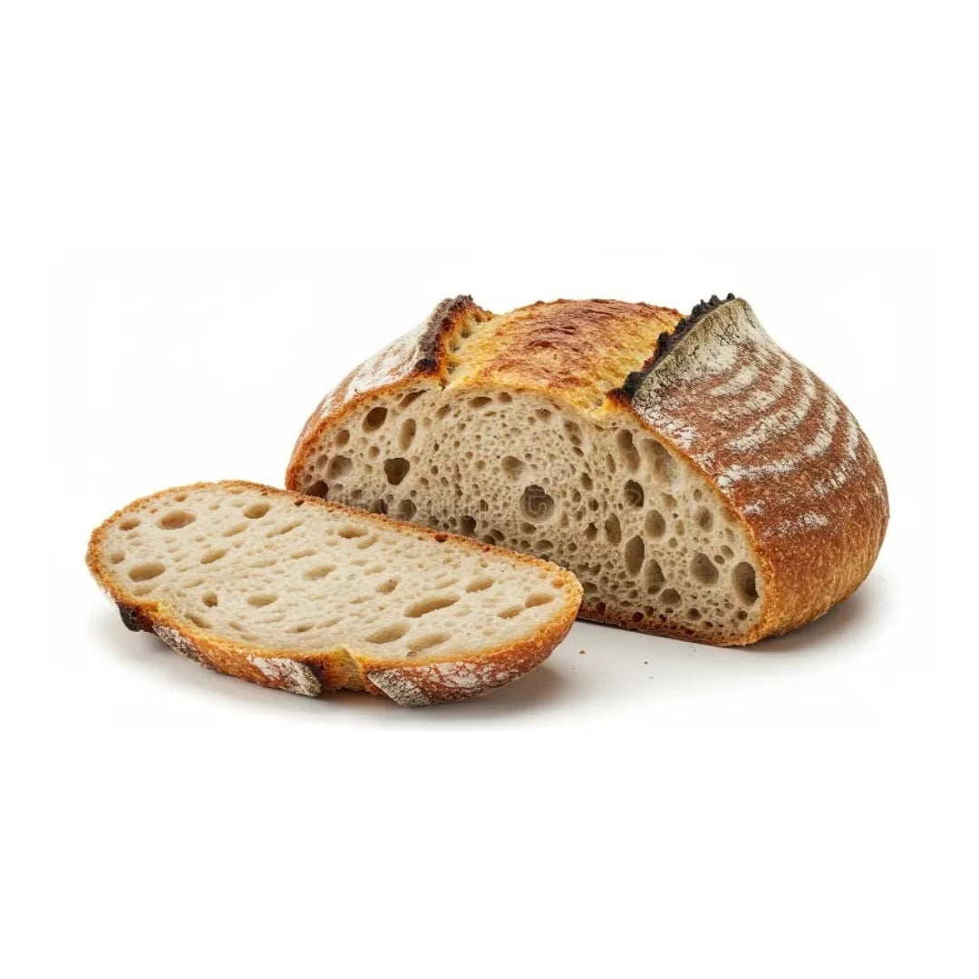 Hogaza de pan de masa madre cortada con una rebanada al lado, mostrando su miga alveolada y corteza dorada, disponible en Nutribody en variedades con semillas, arándano y nuez, dátil y romero, o aceituna negra.