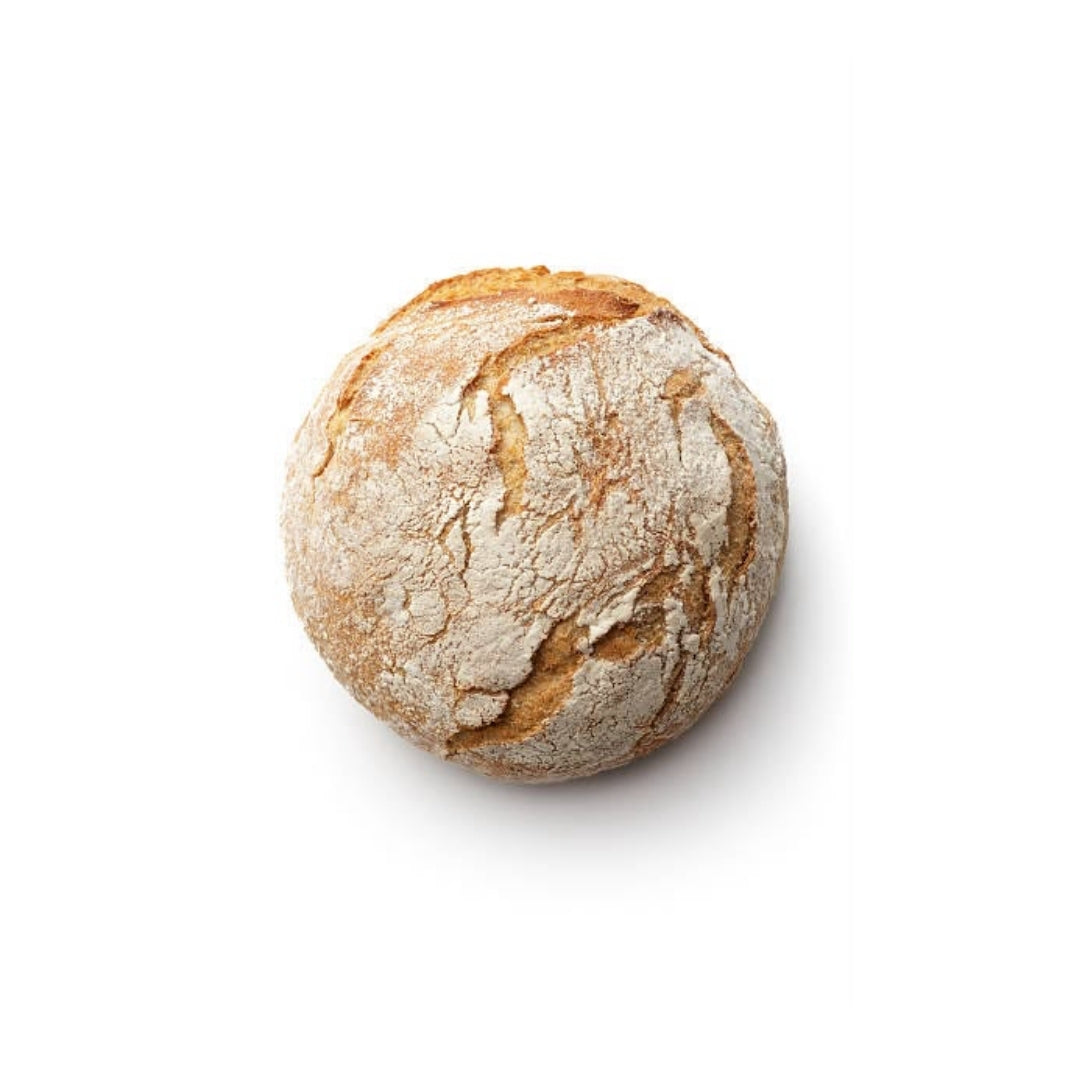 Vista superior de una hogaza redonda de pan de masa madre con corteza enharinada y dorada, a la venta en Nutribody en variedades con semillas, arándano y nuez, dátil y romero, o aceituna negra.